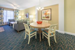 默特尔比奇南海滩假日俱乐部温泉酒店 的用餐室以及带桌椅的起居室。