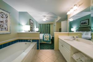 默特尔比奇南海滩假日俱乐部温泉酒店 的带浴缸的浴室和1间带1张床的卧室