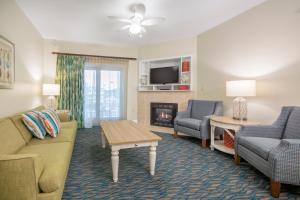 默特尔比奇南海滩假日俱乐部温泉酒店 的客厅配有沙发、椅子和壁炉