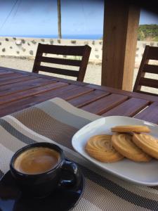 Faja GrandeFajazinha Cottage的盘子上的饼干和一杯咖啡