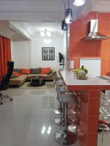 达喀尔Appartement Confort Fann hock的厨房设有橙色墙壁和白色台面