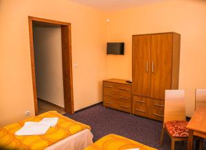 利普托斯基米库拉斯福科旅馆的客房设有两张床、一个橱柜和一张桌子。