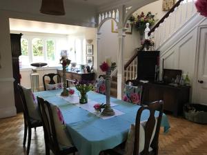 布里斯托Coombe Lodge Farm House的一间用餐室,里面摆放着鲜花,摆放着蓝色的桌子