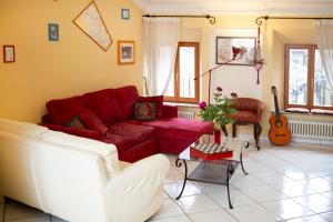 雷卡纳蒂Porta Marina的客厅配有红色沙发和吉他