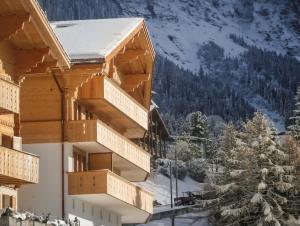 翁根Holiday flat #1, Chalet Aberot, Wengen, Switzerland的一座有雪覆盖的山的建筑