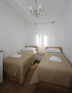 马卡尔斯卡Apartments Obitelj Vuletić的客房设有两张床和吊灯。