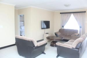 UlundiMbopha Guest House的客厅配有两把椅子和一张桌子
