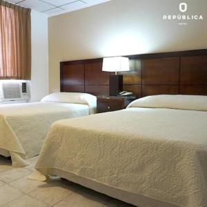 巴拿马城Hotel República Panamá的酒店客房,设有两张床和一盏灯