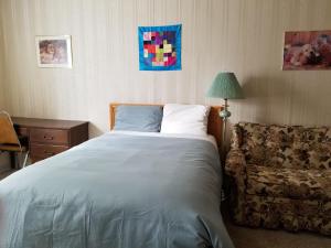 MelvilleMelsask Motel的一间卧室配有床、沙发和灯