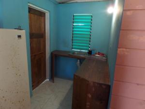 尼格瑞尔Jah B's Cottages on Beach Road-Negril的客房设有木桌和窗户。
