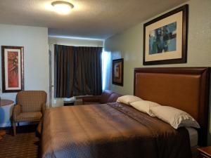 代托纳海滩代托纳圣马瑞娜汽车旅馆的配有一张床和一把椅子的酒店客房