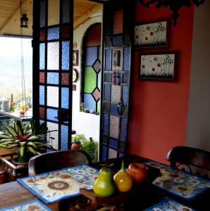 索波El Pedregal Sopó的一间设有桌子和彩色玻璃窗的用餐室