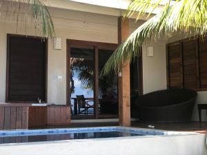 维拉港艾拉克岛水疗度假酒店的房屋前有游泳池的房子