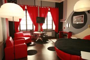 华沙城堡酒店的一间卧室配有红色的床、椅子和桌子