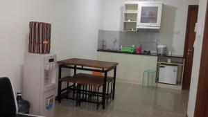 雅加达Robert's Condominium的厨房配有桌子、两把凳子和冰箱。