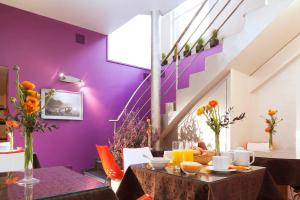 巴黎帕西小村酒店的一间拥有紫色墙壁和鲜花桌的用餐室