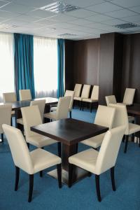布热茨拉夫博斯运动休闲中心俱乐部酒店的一间会议室,配有桌子和白色椅子