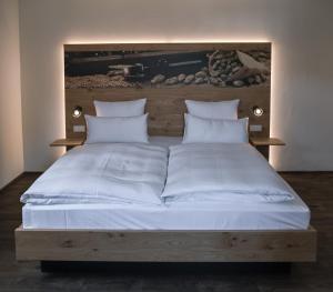 埃兴Bierhotel - Hotel & Brauereigasthof Schneider的一张配有白色床单和枕头的大床