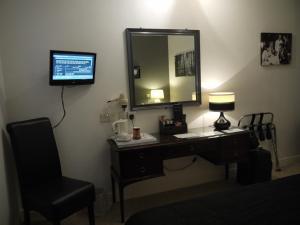 Barnby Dun洛奇旅馆的一张带镜子的桌子、一盏灯和一把椅子