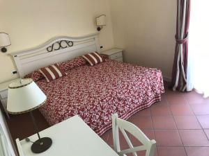 阿布鲁齐的罗塞托罗塞拉度假别墅酒店的一间卧室配有一张床和一张带台灯的桌子