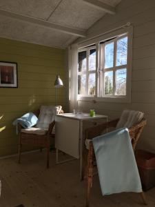 尼克宾摩斯Heltoften Bed & Breakfast的配有椅子和桌子的房间以及窗户