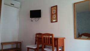 洛斯卡尼奥斯德梅卡迷你高尔夫旅舍的客房设有书桌和墙上的电视