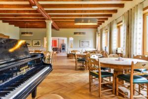 巴特科尔格鲁布SEINZ Wisdom Resort - Bio-Hotel vegan-vegetarisch的配有钢琴和桌椅的房间