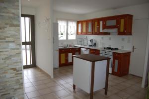 GaronsLa Maison de Peggy的厨房配有棕色橱柜和白色台面