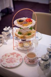 伦敦Thistle London Holborn的桌子上放着三明治托盘和一杯茶