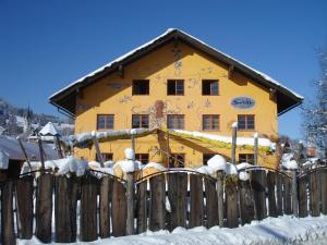 Bihlerdorf希夫比勒尔朵夫旅舍的雪中带围栏的黄色房子