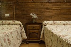 索托德坎加斯康洪托帕塞拉酒店的一间卧室配有两张床和一张鲜花桌