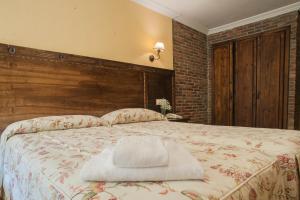 索托德坎加斯康洪托帕塞拉酒店的一间卧室配有一张大床和木制床头板