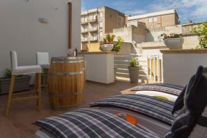 马尔萨拉Il Sogno Apartments的一个带枕头和屋顶桶的阳台