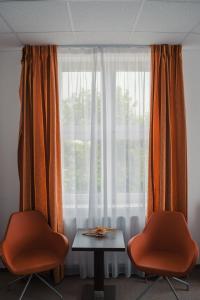 布热茨拉夫博斯运动休闲中心俱乐部酒店的窗前的一张桌子和两把椅子