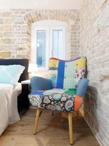 斯普利特Studio apartment Milla的一张五彩缤纷的椅子,放在一个配有床的房间