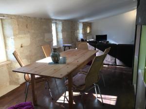 布莱Gite la Tropezienne的客厅配有一张木桌和椅子