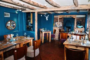 布由德利皇家森林乡村酒店的一间拥有蓝色墙壁和木桌及椅子的用餐室