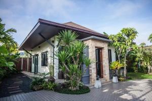 奥南海滩Baan Pinya Cosy One Bedroom Executive Bungalow的前面有棕榈树的房子