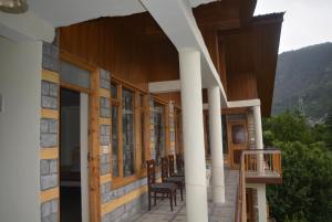 马拉里Himalaya Cottage的一个带椅子和窗户的门廊