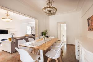 VátosDespina House Ermones的一间带木桌和白色椅子的用餐室