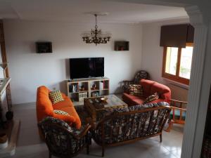 罗德里戈城El Cerezo的客厅配有两把椅子、一张桌子和一台电视