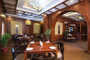 兰奇Chanakya Bnr Hotel的一间在房间内配有桌椅的餐厅
