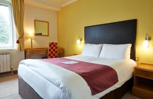 福里斯特罗Roebuck by Greene King Inns的一间位于酒店客房内的带大床的卧室