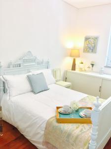 波尔图BS Villas Porto的卧室配有白色的床,并备有托盘