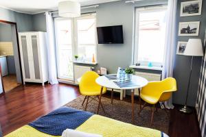 科沙林中心公寓的客厅配有桌子和黄色椅子