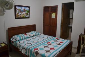 巴兰基亚Hotel Granada Inn的一间卧室配有一张带五颜六色棉被的床