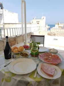 滨海波利尼亚诺Dimora La Nicchia的餐桌,餐盘和一杯葡萄酒