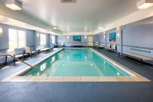 伊丽莎白镇Country Inn & Suites by Radisson, Elizabethtown, KY的医院里的一个游泳池,配有桌椅