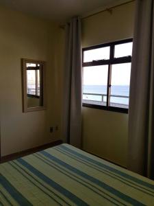 阿拉亚尔-杜卡布Caribe Brasileiro a 2 passos da areia的一间卧室设有一张床和一个海景窗户