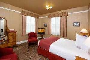 普雷斯科特哈沙扬帕酒店的酒店客房配有一张床、一把椅子和一台电视。